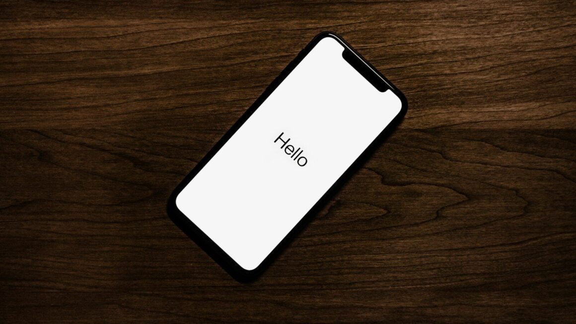 turned on iPhone on top of brown wooden surface